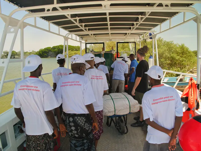 Équipe de bénévoles en casquette sur le pont du bateau.