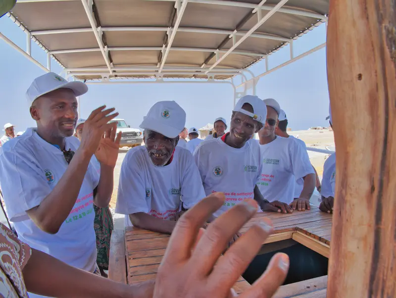 Bénévoles souriants à bord du bateau.